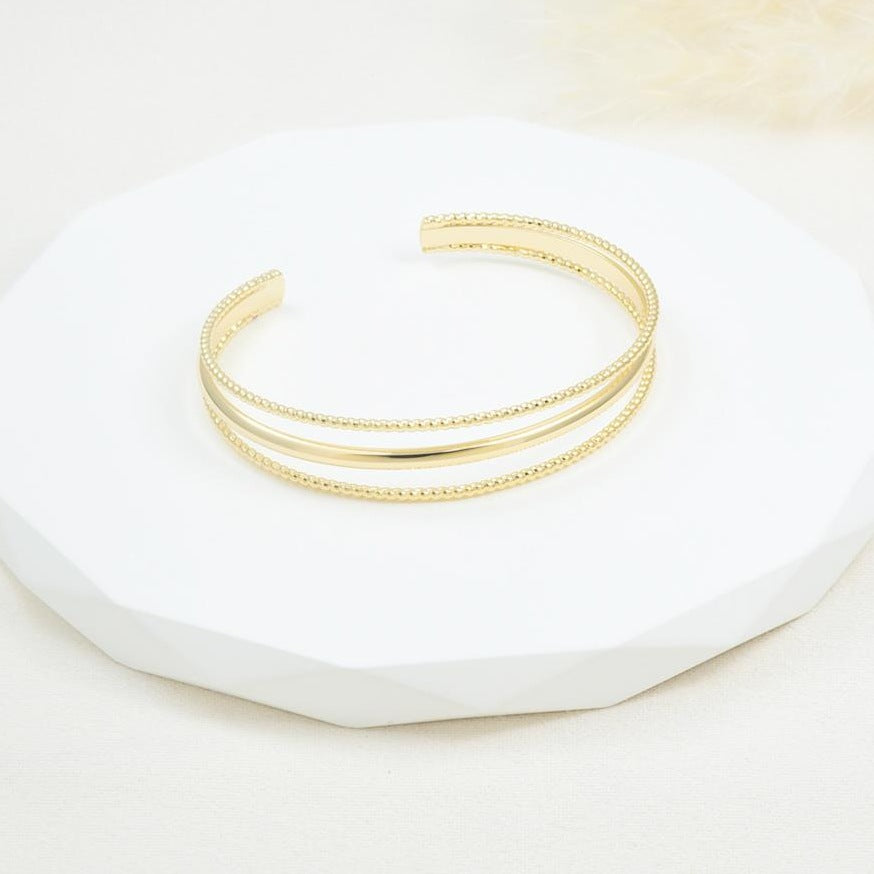 Brazalete rígido de triple línea en baño de rodio dorado | Feral